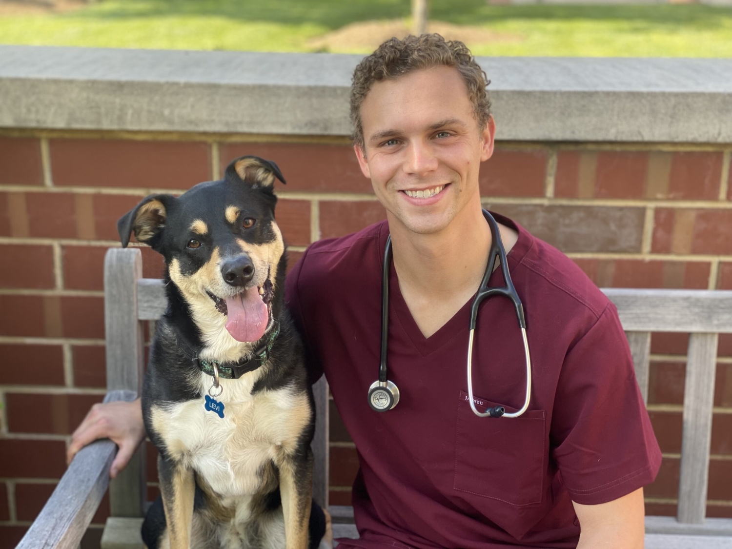 veterinarian sits with dog on bench