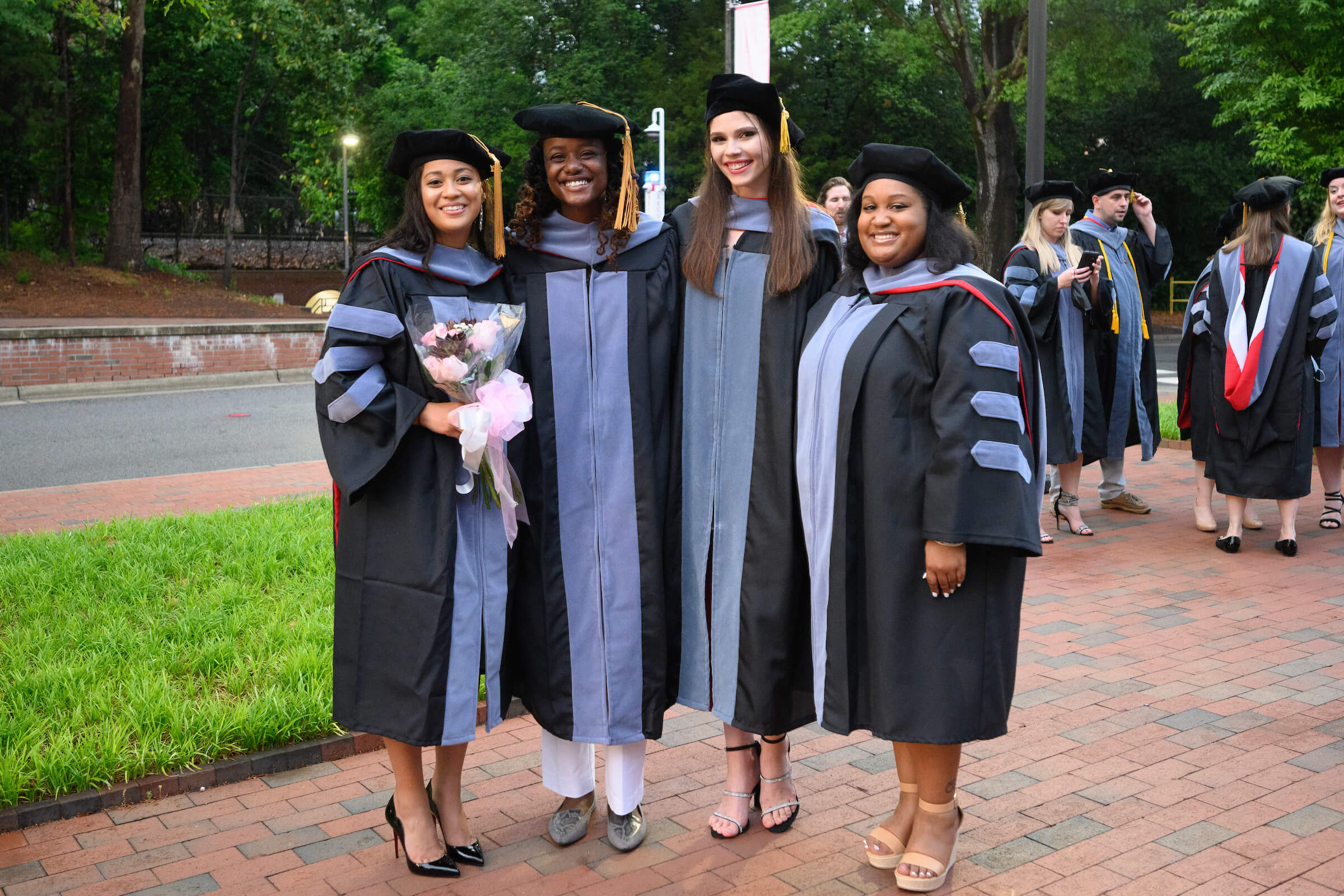 four women smile for a picture in their DVM graduation gowns