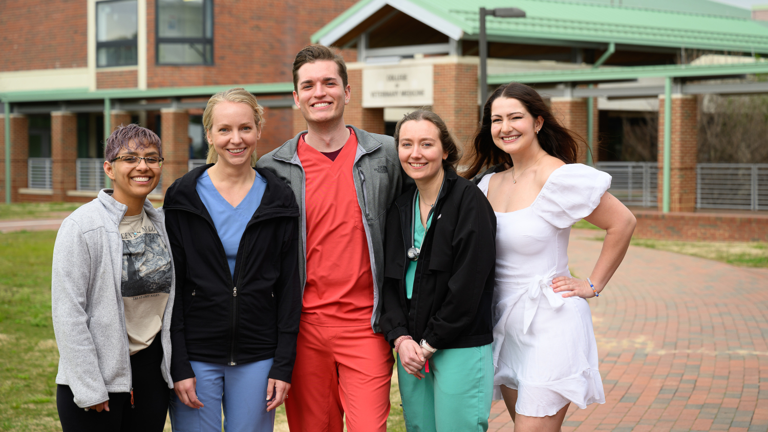 Five future pathology residents from the DVM Class of 2024, four females and one male, stand outside of the NC State College of Veterinary Medicine.