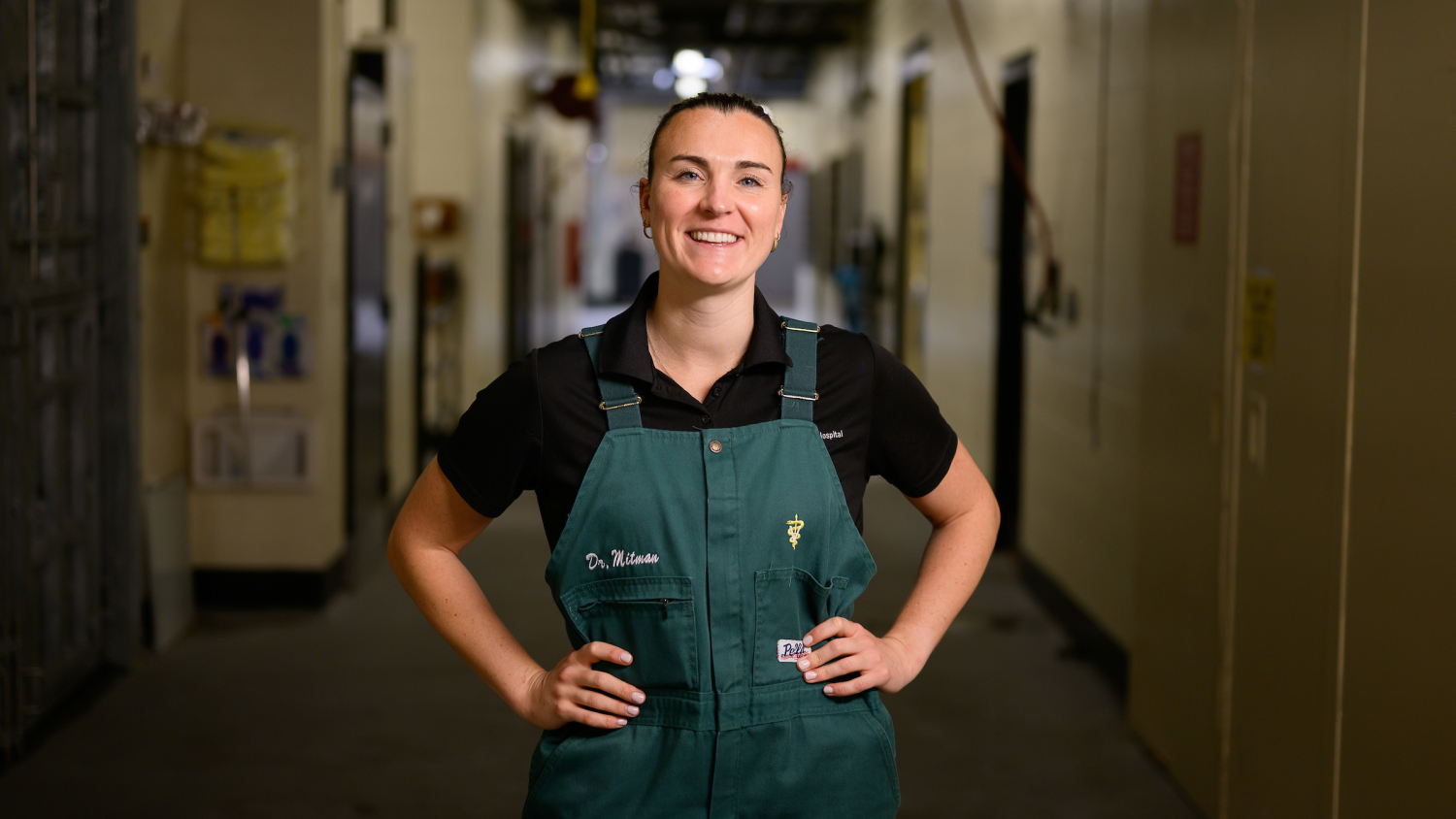 Dr. Siena Mitman poses in a hallway of the NC State Large Animal Hospital with her hands on her hips.