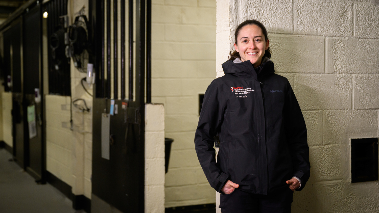 Dr. Sara Tufts stands in front of stalls at the NC State Large Animal Hospital.