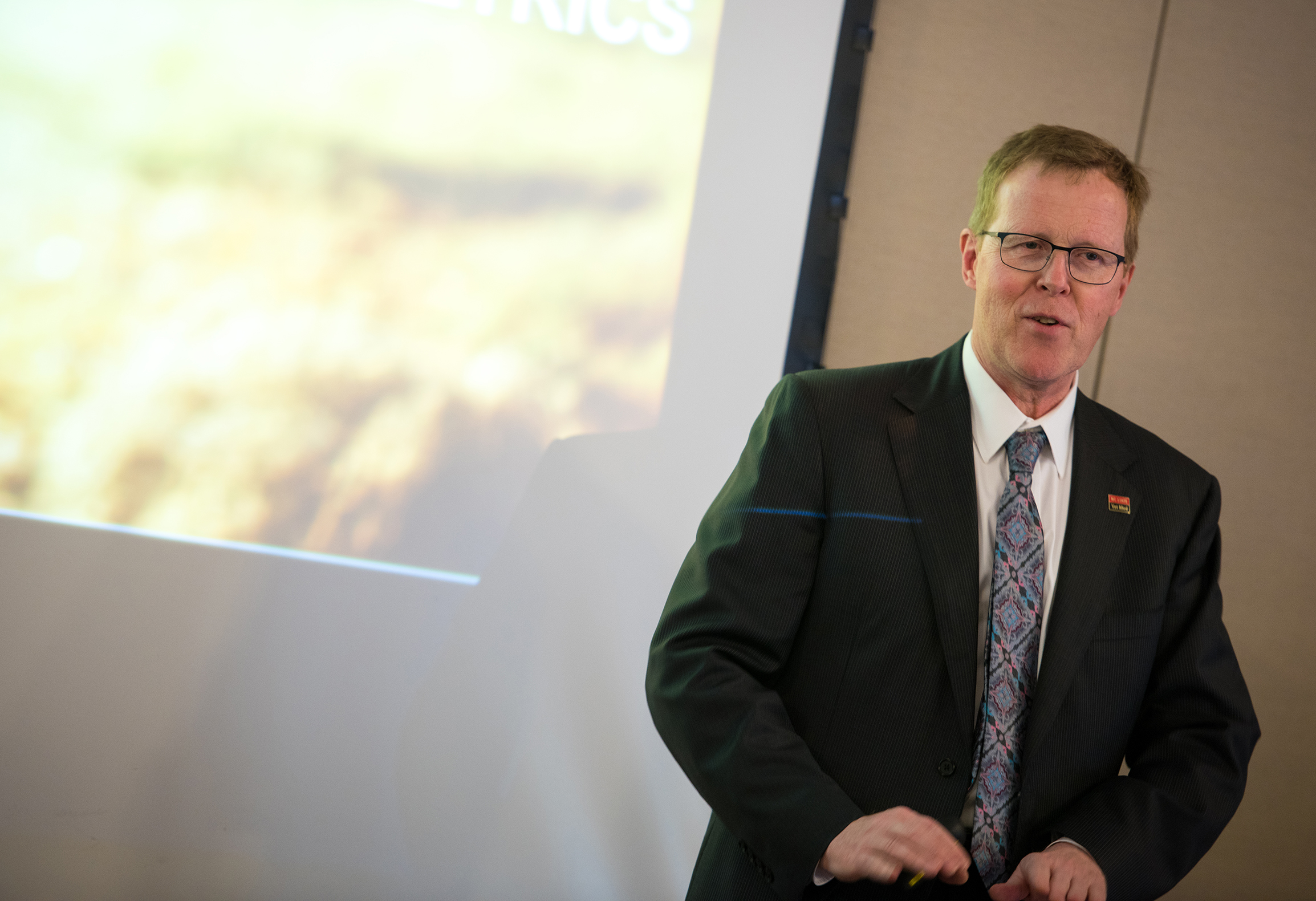 Man in suit in front of presentation
